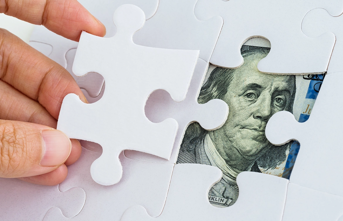 An image of a US dollar note under a puzzle